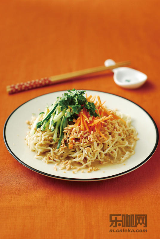 将熟凉面放入盘内,淋上传统芝麻酱,再放入小黄瓜丝,红萝卜丝,食用时