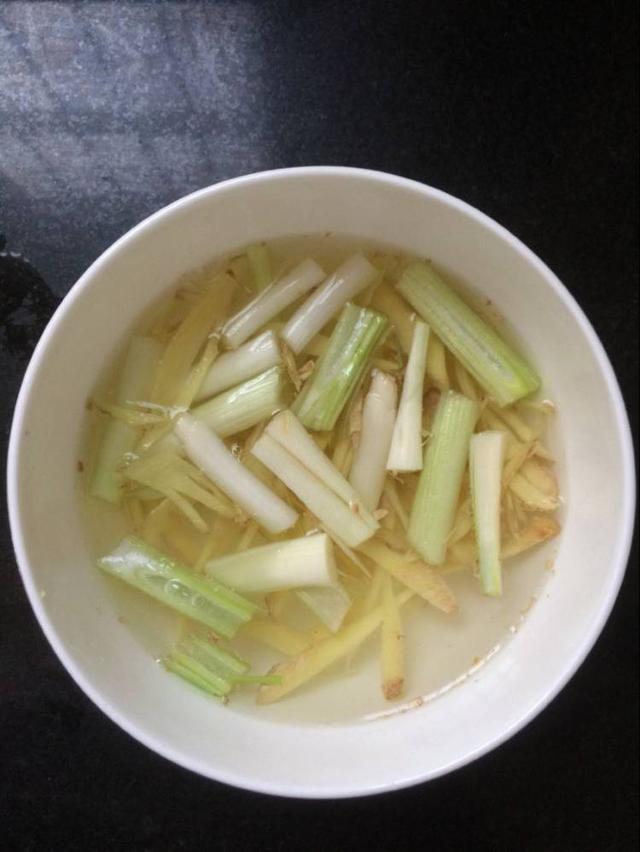 3 锅中烧水,淋入料酒将螃蟹肚子朝上撒入葱姜上火蒸15分钟放上葱姜段