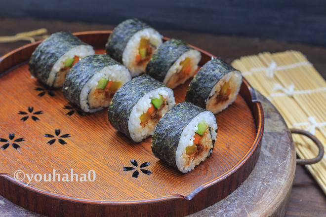 快刀沾一点凉开水,切开紫菜卷即可借助于寿司帘卷起,捏紧在小酱上摆放
